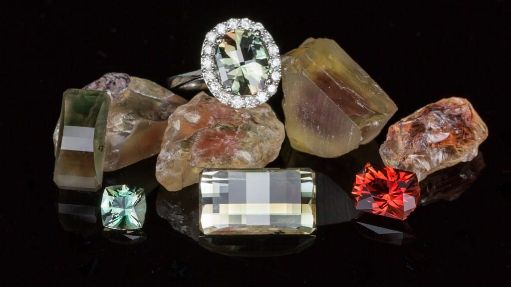This image highlights the diversity of colors to be found in Oregon sunstone.  Rough gem material from the Sunstone Butte and Double Eagle 16 mines is paired with cut stones from both mines and ring made from a green and orange sunstone.