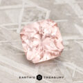 A 1.84-carat Pink-Peach Pastel Pyrope Garnet with a cushion cut rests on a textured gray surface, featuring the words "EARTH'S TREASURY" and a hexagonal logo beneath it.