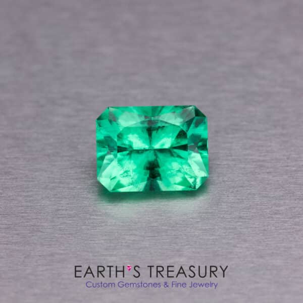 A 1.48-carat Ethiopian emerald, featuring a rectangular emerald cut, is displayed on a metallic gray surface. Below the gem, the text reads "Earth's Treasury: Custom Gemstones & Fine Jewelry.