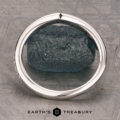A platinum “Faye” band encircles a rough, dark green stone, displayed on a textured gray surface with the Earth’s Treasury logo at the bottom.