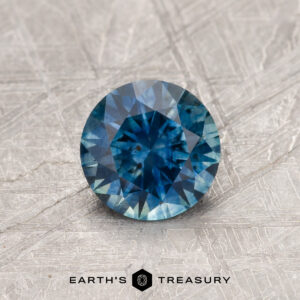 A blue-green Montana sapphire in a classic diamond round brilliant design