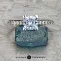 The "Meissa" ring—crafted in 14K white gold with a 1.47-carat Montana sapphire—is shown on a rough blue crystal, set against a textured gray background.