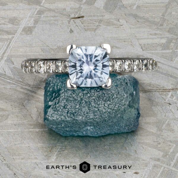 The "Meissa" ring in 14K white gold with 1.47-carat Montana sapphire The "Meissa" ring—crafted in 14K white gold with a 1.47-carat Montana sapphire—is shown on a rough blue crystal, set against a textured gray background.