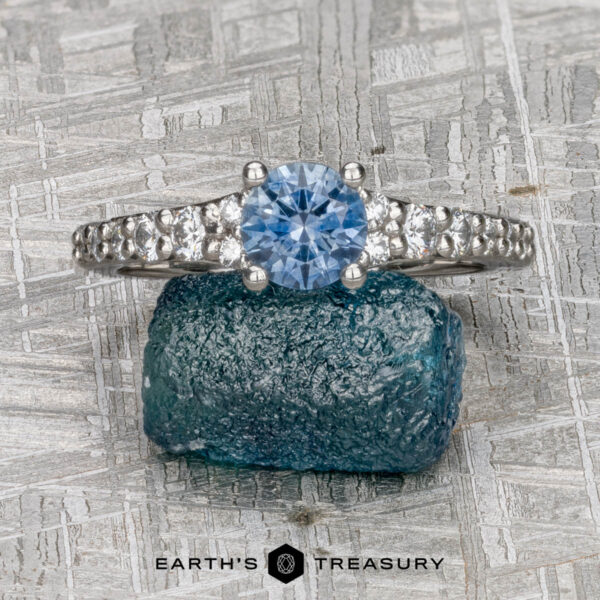 The "Arethusa" ring in platinum with 0.82-carat Montana sapphire The "Arethusa" ring features a platinum band with a 0.82-carat Montana sapphire center, elegantly displayed on rough blue crystal, with the Earth’s Treasury logo below.