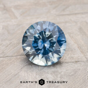 A blue-green Montana sapphire in a classic diamond round brilliant design