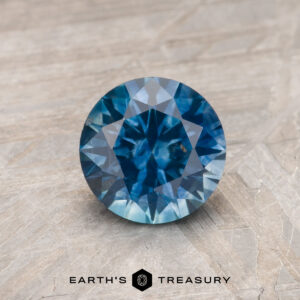 A blue-green Montana sapphire in a classic diamond round brilliant design