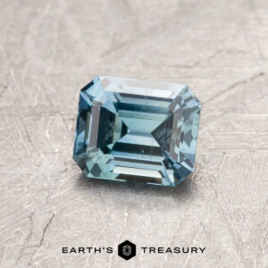 A blue-green Montana sapphire in a classic emerald cut