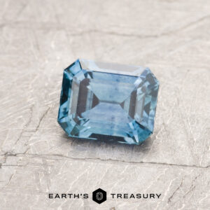 A blue-green Montana sapphire in a classic emerald cut