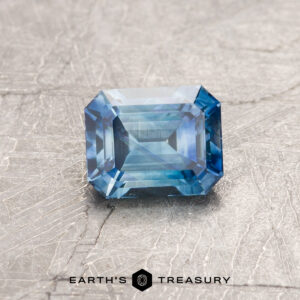 A blue-green Montana sapphire in a classic emerald cut