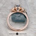 The "Liriope" ring in 14k rose gold features a 1.40-carat Montana sapphire, elegantly set atop a rough blue stone and displayed with the Earth's Treasury logo below.