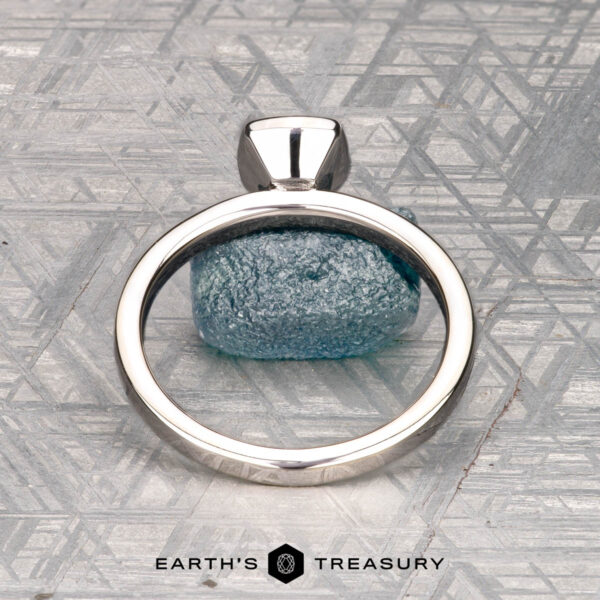 McMinn, Richard and Gomez, Eric A solitaire ring with a rough blue gemstone is shown on a gray patterned surface, labeled "McMinn, Richard and Gomez, Eric" below.