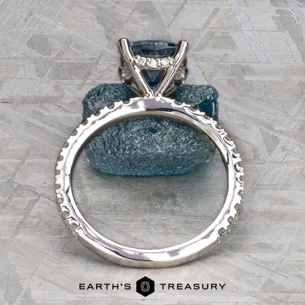 The "Amphitrite" ring in platinum with 1.81-carat Montana sapphire A platinum "Amphitrite" ring with a 1.81-carat Montana sapphire is displayed upright on a textured blue stone background, with the text "EARTH'S TREASURY" below.