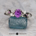 The "Jasmine" ring in platinum, featuring a 1.03-carat Madagascar sapphire, is displayed on a rough blue crystal with the "Earth's Treasury" logo below.