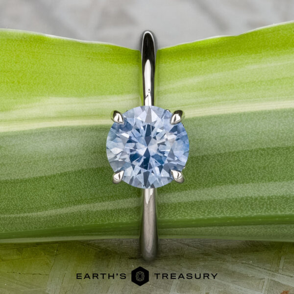 The "Tiara" ring in platinum with 2.00-carat Montana sapphire The "Tiara" ring in platinum features a 2.00-carat Montana sapphire, showcased atop a green leaf with "Earth's Treasury" displayed below.