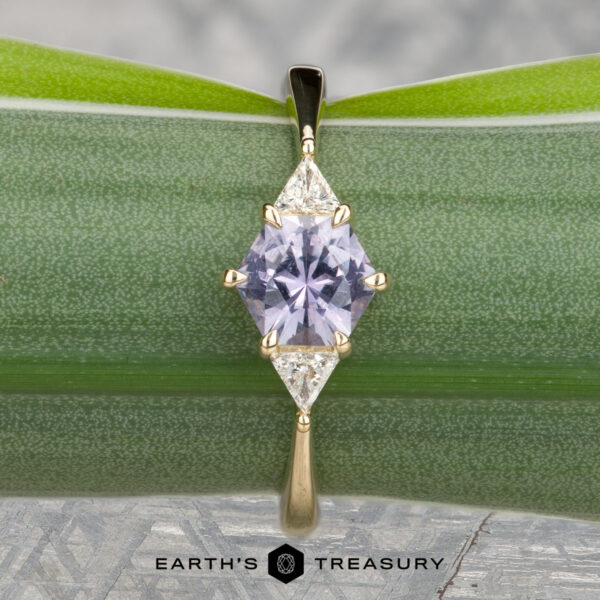 The "Melilai" ring in 14k yellow gold with 1.06-carat Montana sapphire The "Melilai" ring in 14k yellow gold features a 1.06-carat Montana sapphire and two clear stones, elegantly displayed on a green leaf with the Earth's Treasury logo below.
