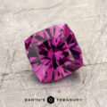 A square-cut, deep purple gemstone—ET1993—evokes the striking allure of a magenta garnet as it rests on a textured gray surface. The words "EARTH'S TREASURY" appear at the bottom of the image.