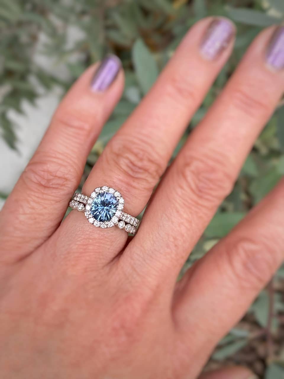 A photo from a customer review featuring a classic pave halo ring in platinum with 2.07-Carat Montana sapphire, alongside the "Loire" band in platinum