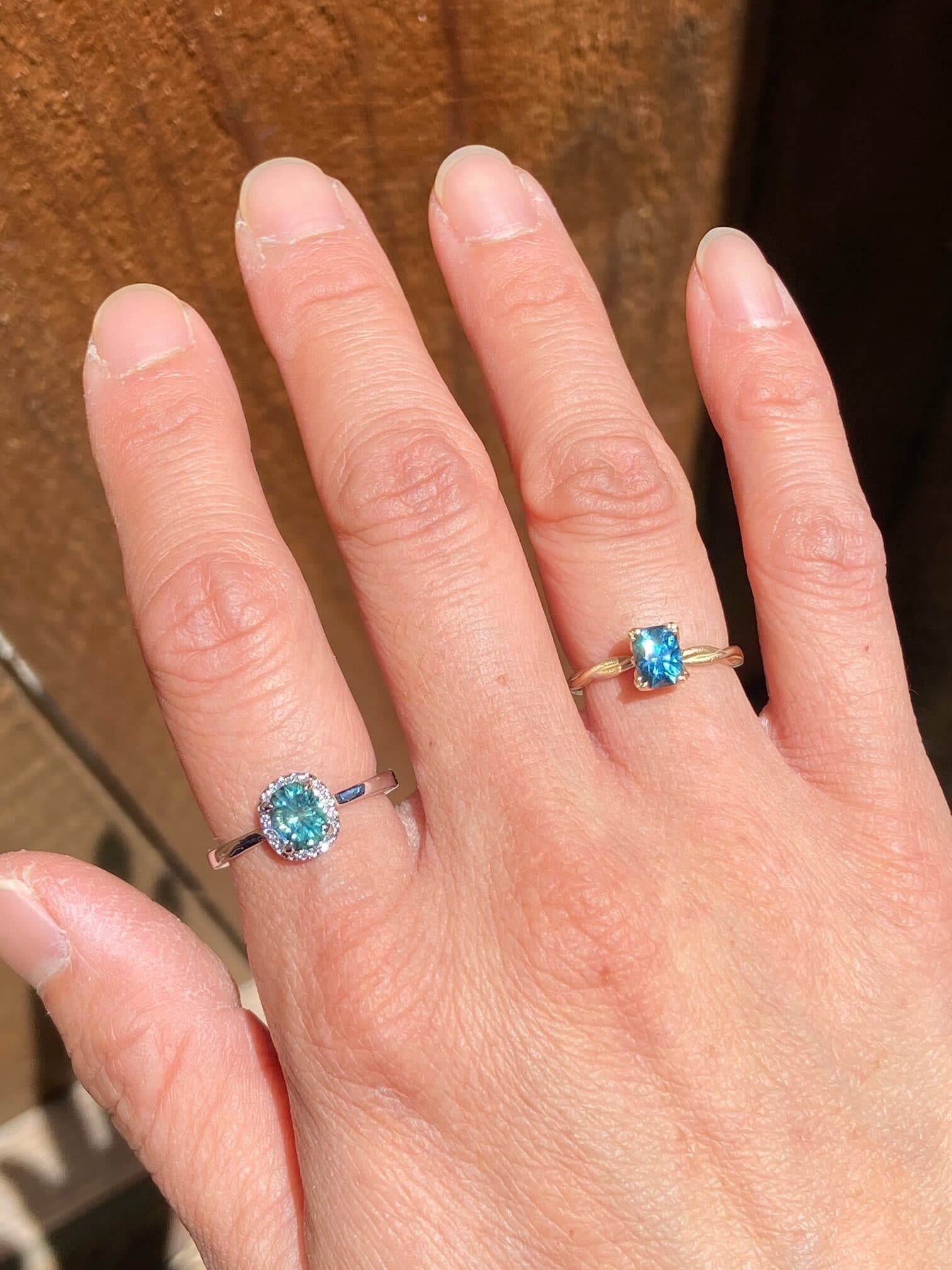 A photo from a customer review featuring two rings. On the left, an "Alice" ring in 14k white gold with 0.96-Carat Montana Sapphire. On the right, a ring not made by Earth's Treasury with a 0.88-Carat Montana Sapphire.