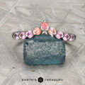 The "Dahlia" band in platinum, set with pink and orange gemstones, is shown on a rough blue stone. The text "Earth's Treasury" appears at the bottom.