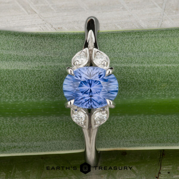 The "Hazel" ring in platinum with 1.10-carat Ceylon sapphire The Hazel ring in platinum, featuring a 1.10-carat Ceylon sapphire at the center, is elegantly showcased on a green leaf.