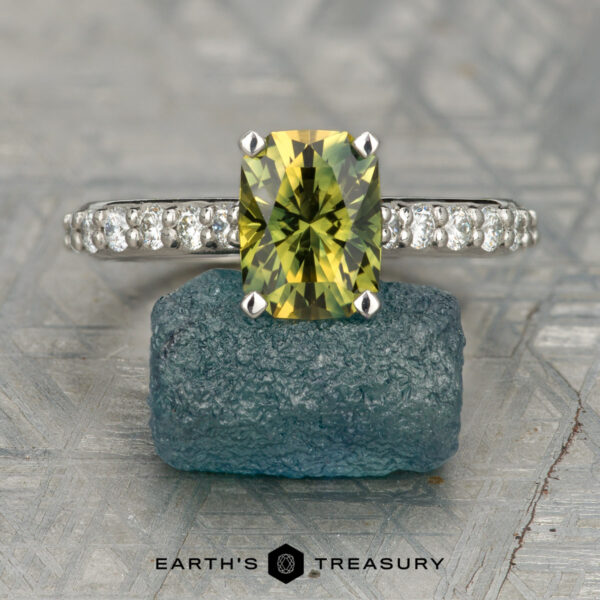 The "Aquila" ring in platinum with 2.24-carat Australian sapphire The "Aquila" ring in platinum, featuring a 2.24-carat Australian sapphire, stands upright on a rough blue stone with the "Earth's Treasury" logo below.