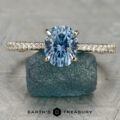 The Tatiana ring displayed upright on a rough blue stone, with "Earth's Treasury" text below.