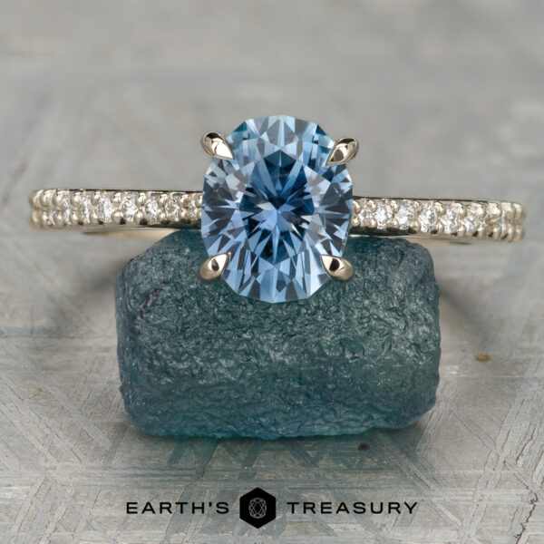 2026-03-11 08-44-25 (B,R14,S2)-1200-BW The Tatiana ring displayed upright on a rough blue stone, with "Earth's Treasury" text below.