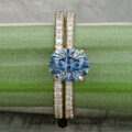 Tatiana Ring with a diamond band is displayed on a green plant stem. The "Earth's Treasury" logo appears at the bottom.