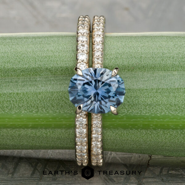 2026-03-11 08-47-08 (B,R14,S2)-1200-BW Tatiana Ring with a diamond band is displayed on a green plant stem. The "Earth's Treasury" logo appears at the bottom.