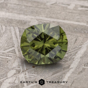 A 1.78-carat dark olive green Australian sapphire with a cushion cut is showcased on a textured metallic surface, featuring the "Earth's Treasury" text at the bottom.