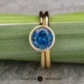 The āLuellaā in 18k yellow gold with 2.06-Carat Montana Sapphire alongside the The Custom-Fit Straight Band in 18k yellow gold