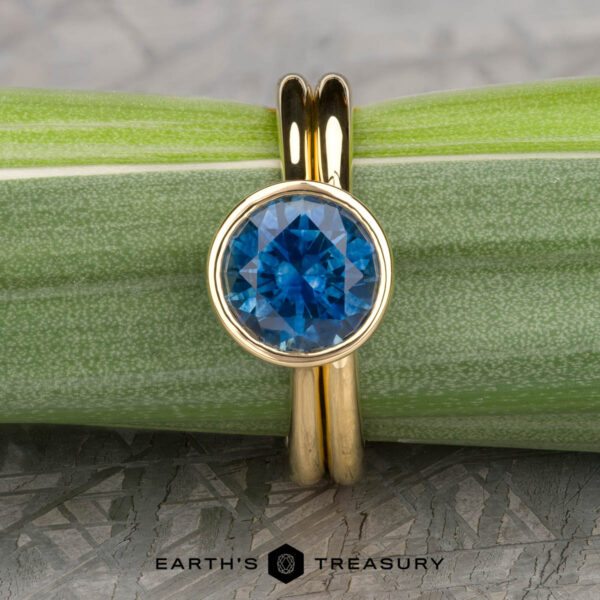The āLuellaā in 18k yellow gold with 2.06-Carat Montana Sapphire alongside the The Custom-Fit Straight Band in 18k yellow gold The āLuellaā in 18k yellow gold with 2.06-Carat Montana Sapphire alongside the The Custom-Fit Straight Band in 18k yellow gold