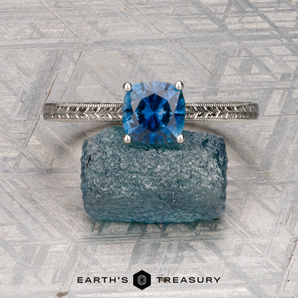 The Engraved "Cathedral" ring in platinum with 1.29-carat Montana sapphire The Engraved "Cathedral" ring in platinum features a 1.29-carat Montana sapphire in a cushion cut, highlighted by intricate band detailing and an elegant engraved cathedral-style solitaire setting.