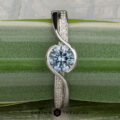 The "Faye" ring in platinum features a 0.92-carat Montana sapphire as its centerpiece and is displayed vertically on a green, striped leaf.