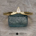 The "Laita" band in 18K yellow gold is showcased elegantly on top of a rock.