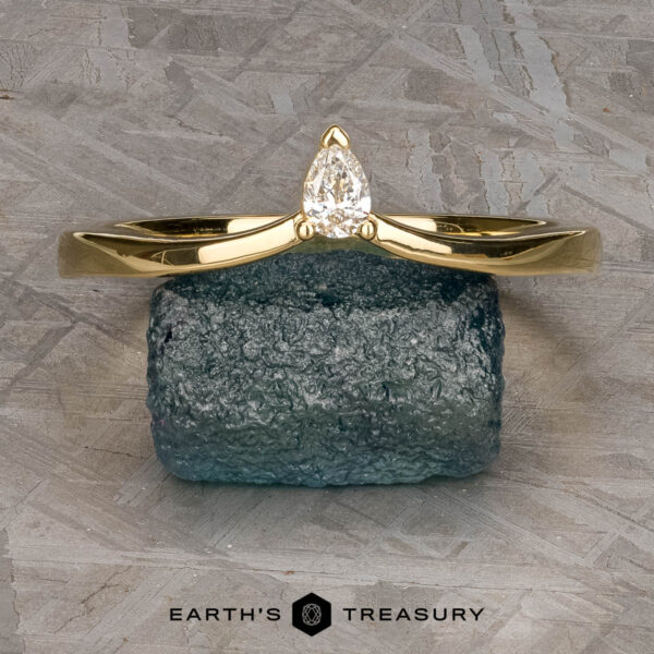 The "Laita" band in 18K yellow gold The "Laita" band in 18K yellow gold is showcased elegantly on top of a rock.