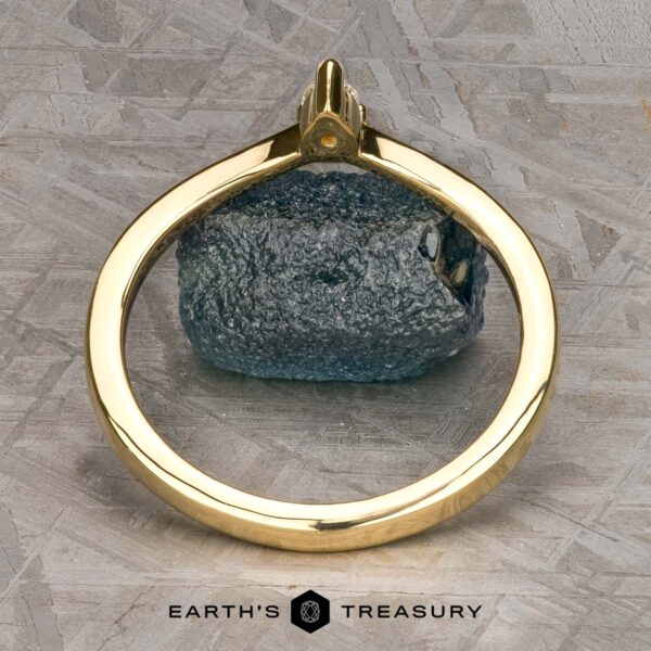 The "Laita" band in 18K yellow gold The "Laita" band in 18K yellow gold is showcased elegantly on top of a rock.