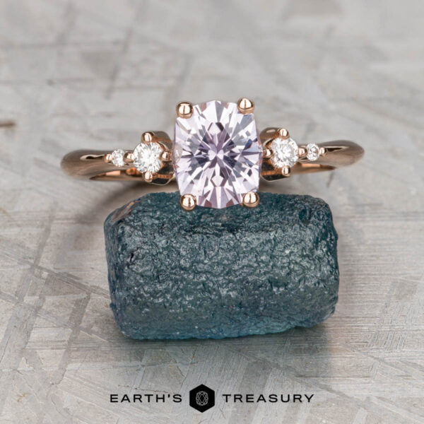 The "Selene" ring in 14K rose gold with 1.11-carat Montana sapphire The "Selene" ring features a 1.11-carat Montana sapphire set in 14K rose gold, accented by two small round diamonds, and elegantly displayed on a rough blue stone.