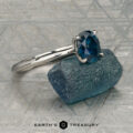 The "Ripple" ring in platinum, featuring a 1.23-carat Montana sapphire, is shown on a rough blue stone with a patterned gray background. "EARTH'S TREASURY" is displayed at the bottom.
