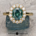 The "Cassandra" ring in 18k yellow gold features a 1.79-carat Montana sapphire and sparkling diamonds, shown on a rough stone with the "Earth's Treasury" logo below.