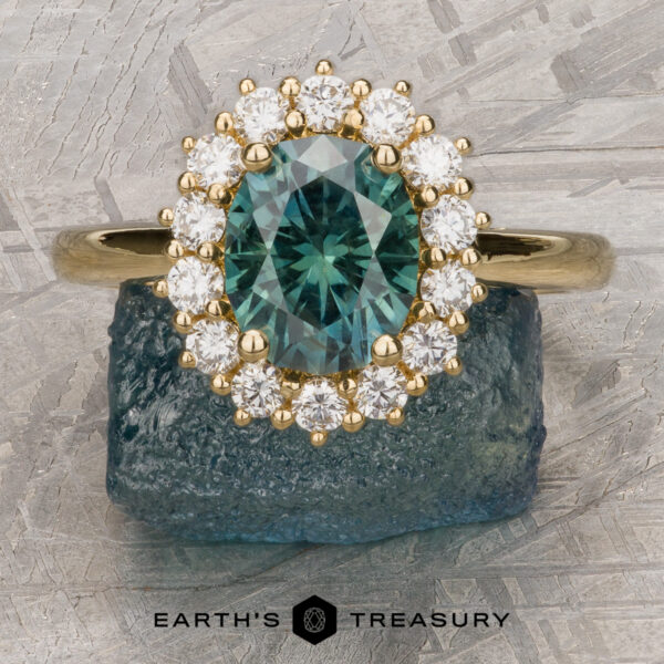 The "Cassandra" ring in 18k yellow gold with 1.79-carat Montana sapphire The "Cassandra" ring in 18k yellow gold features a 1.79-carat Montana sapphire and sparkling diamonds, shown on a rough stone with the "Earth's Treasury" logo below.