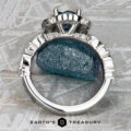 The "Stacked from 54 images. Method=B (R=1,S=4)" ring, featuring a striking blue gemstone and sparkling diamonds, stands upright on a rough blue stone against a textured background, radiating refined Paeonia elegance.