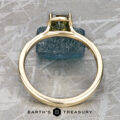 A solitaire ring is displayed upright on a rough blue crystal atop a patterned metallic surface. The "EARTH'S TREASURY" logo appears below, highlighting the elegant Stacked from 56 images. Method=B (R=8,S=4) solitaire.