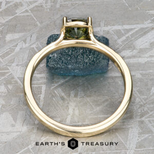 A solitaire ring is displayed upright on a rough blue crystal atop a patterned metallic surface. The "EARTH'S TREASURY" logo appears below, highlighting the elegant Stacked from 56 images. Method=B (R=8,S=4) solitaire.