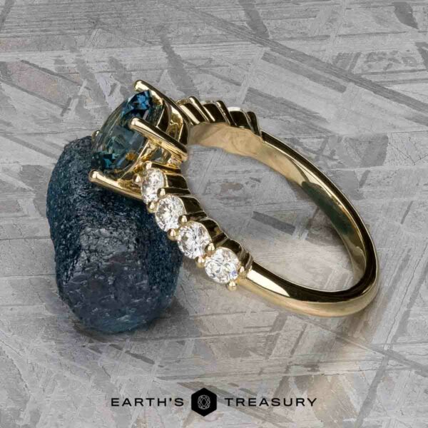 The "Juno" ring in 14k yellow gold with 1.54-carat Montana sapph The "Juno" ring in 14k yellow gold showcases a stunning 1.54-carat Montana sapphire set against a textured surface, enhanced by four diamond-accented details along the band.