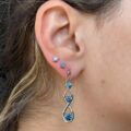 precious metal earrings in a loop shape with blue sapphires
