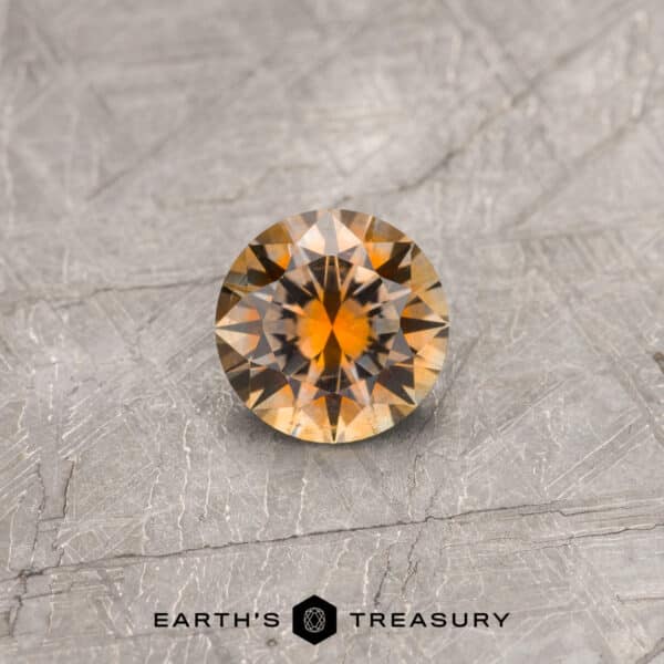 An orange Montana sapphire in a classic diamond round brilliant design
