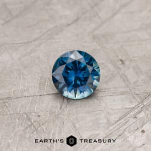 A blue-green Montana sapphire in a classic diamond round brilliant design