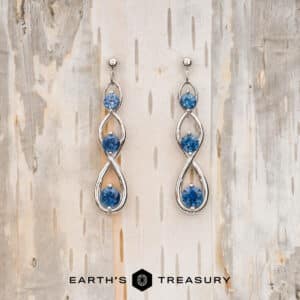 precious metal earrings in a loop shape with blue sapphires
