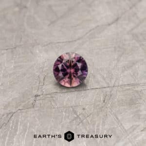 A particolored Umba sapphire in a classic diamond round brilliant design